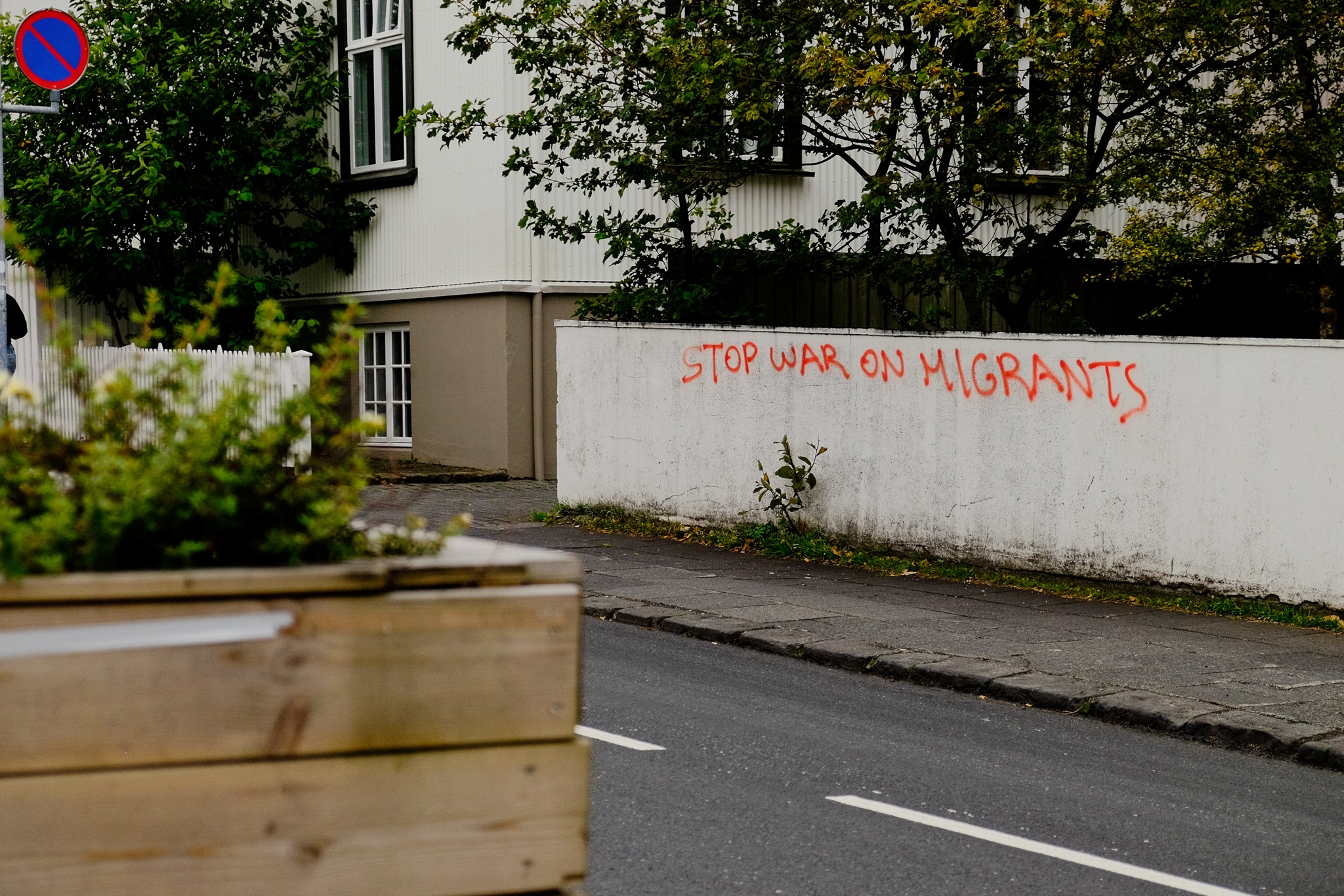 A spray painted sign against a wall in a residential area of the city of Reykjavik reads 