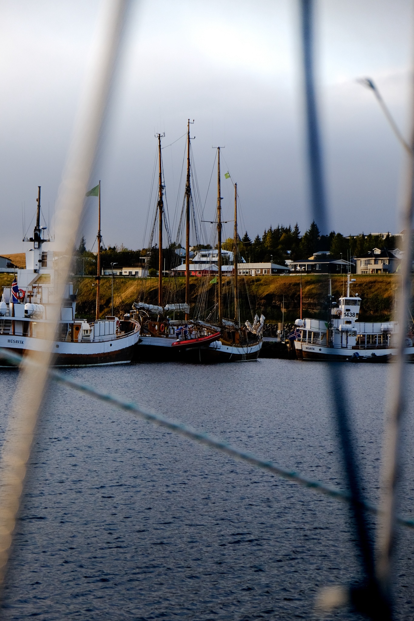 Harbour in Husavik with old wooden boats, the ropes of boat blurred in the foreground